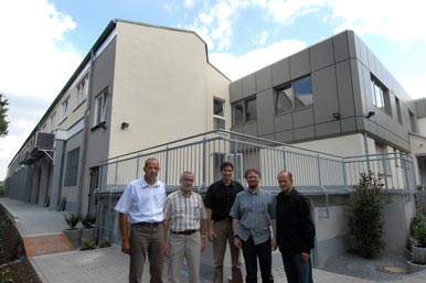 Wolfgang & Stefan Kaiser mit Produktionsmanagern vor der aufgestockten Produktionshalle am Standort Menden